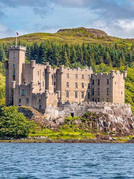 Dunvegan Castle on the Isle of Skye, surrounded by lush greenery and water.