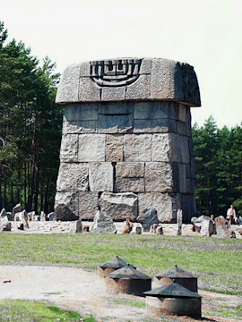 Stone memorial at Treblinka extermination camp site, surrounded by forest.