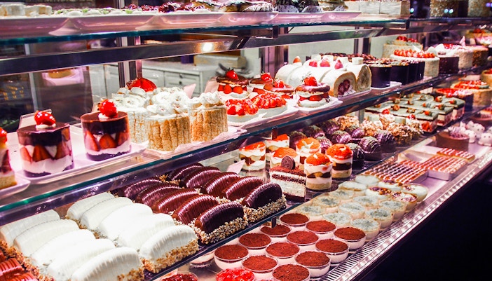 Pastry shop display with assorted cakes and desserts.