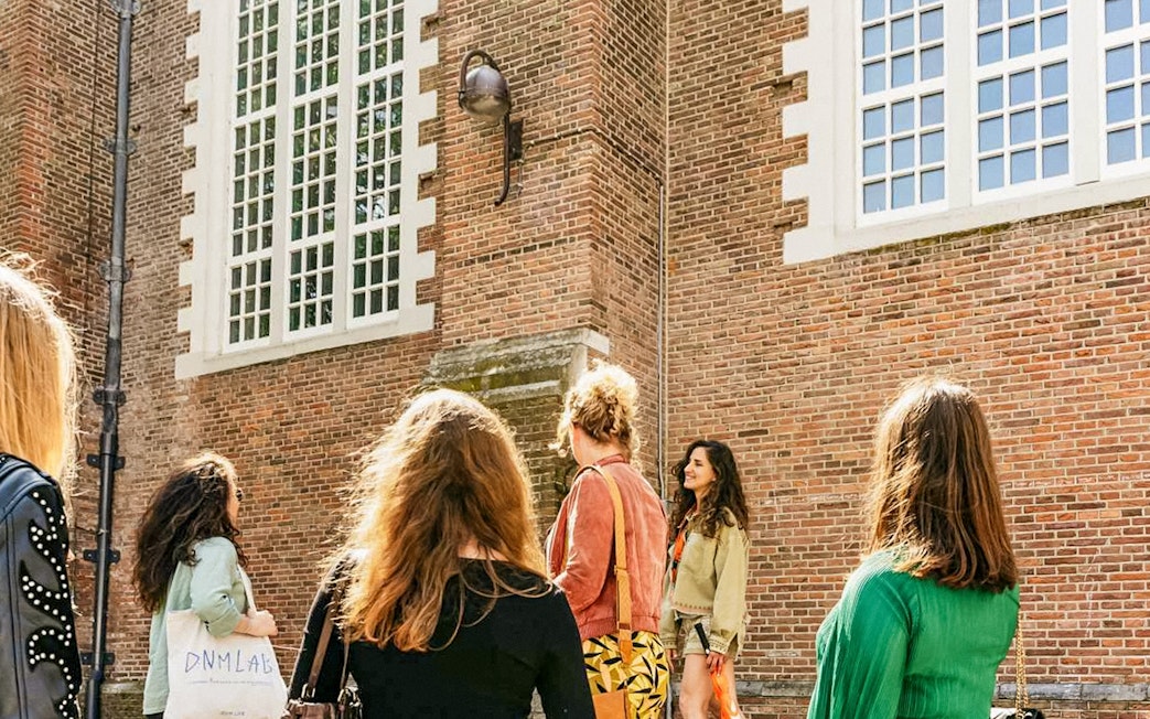 Tour group outside a historic building on the Anne Frank Walking Tour in Amsterdam.