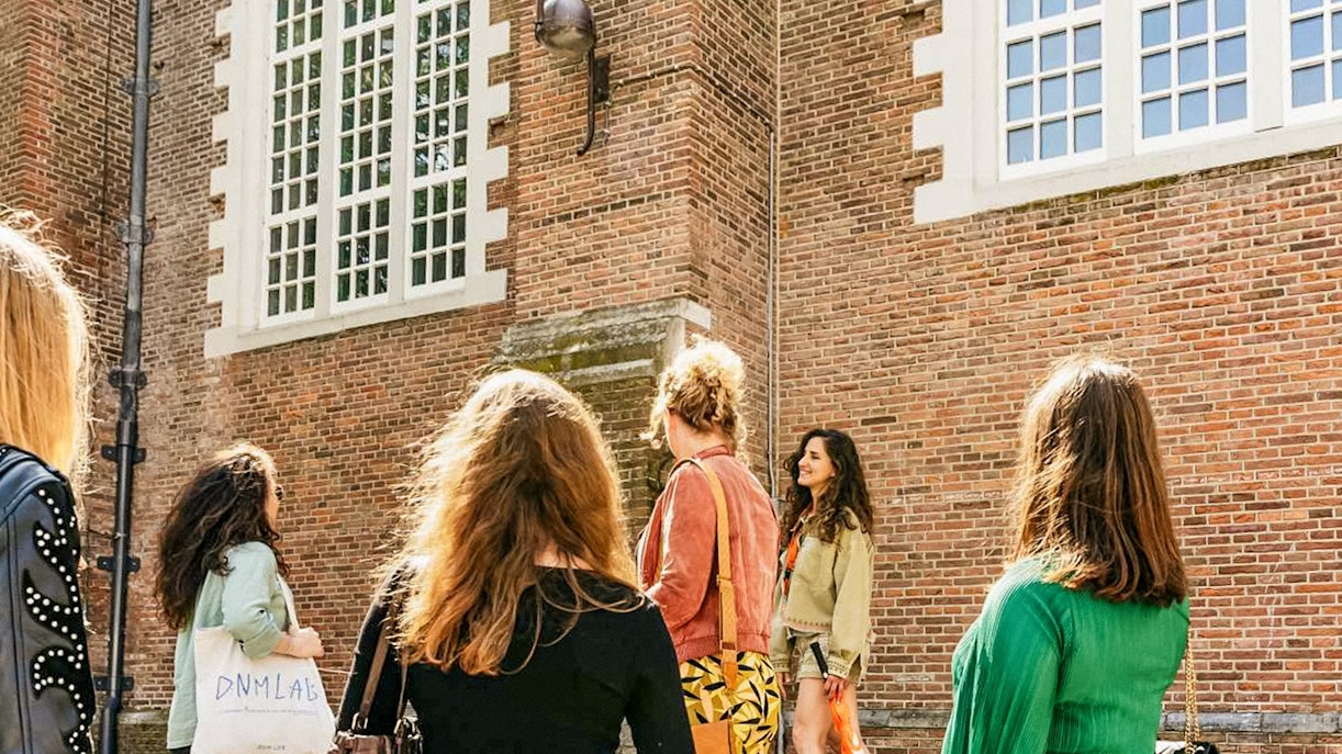 Tour group outside a historic building on the Anne Frank Walking Tour in Amsterdam.