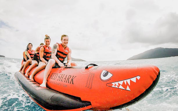Group enjoying a banana boat ride on the Tongarra Sail Day Tour in Whitsundays.
