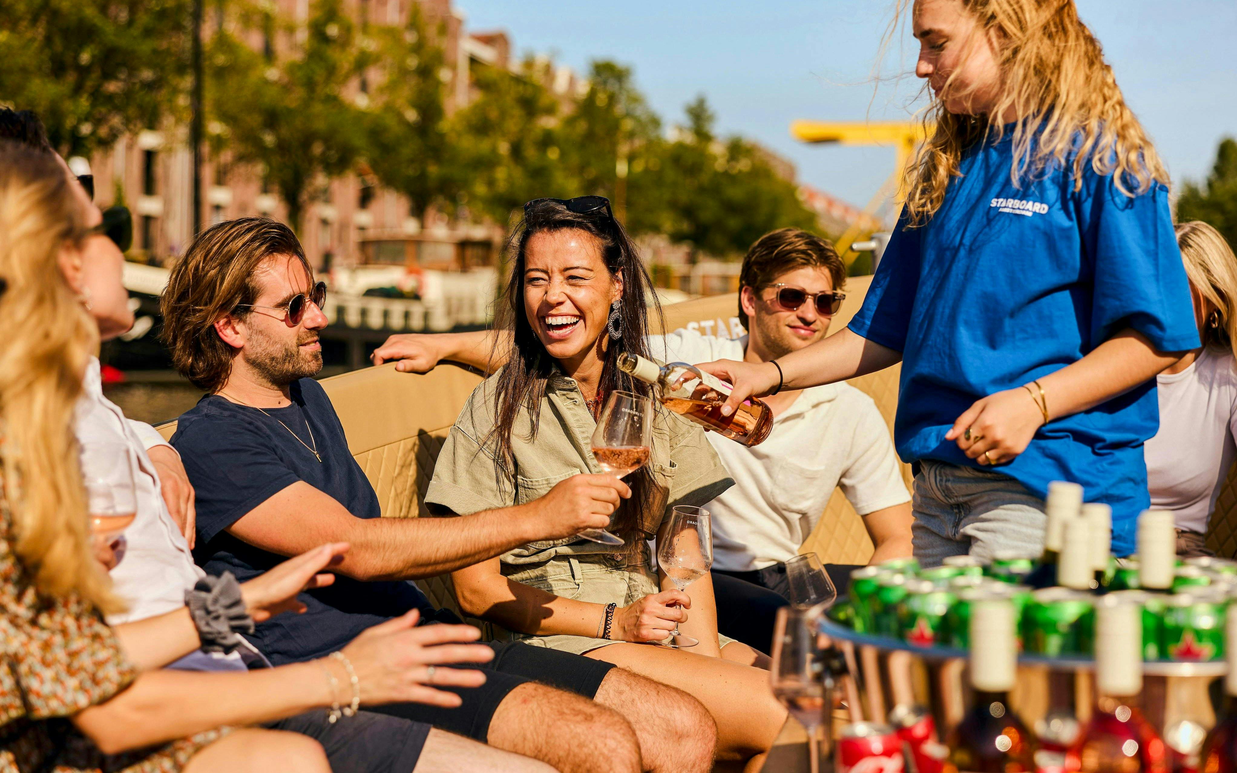 Guests enjoying drinks on a canal cruise in Amsterdam.