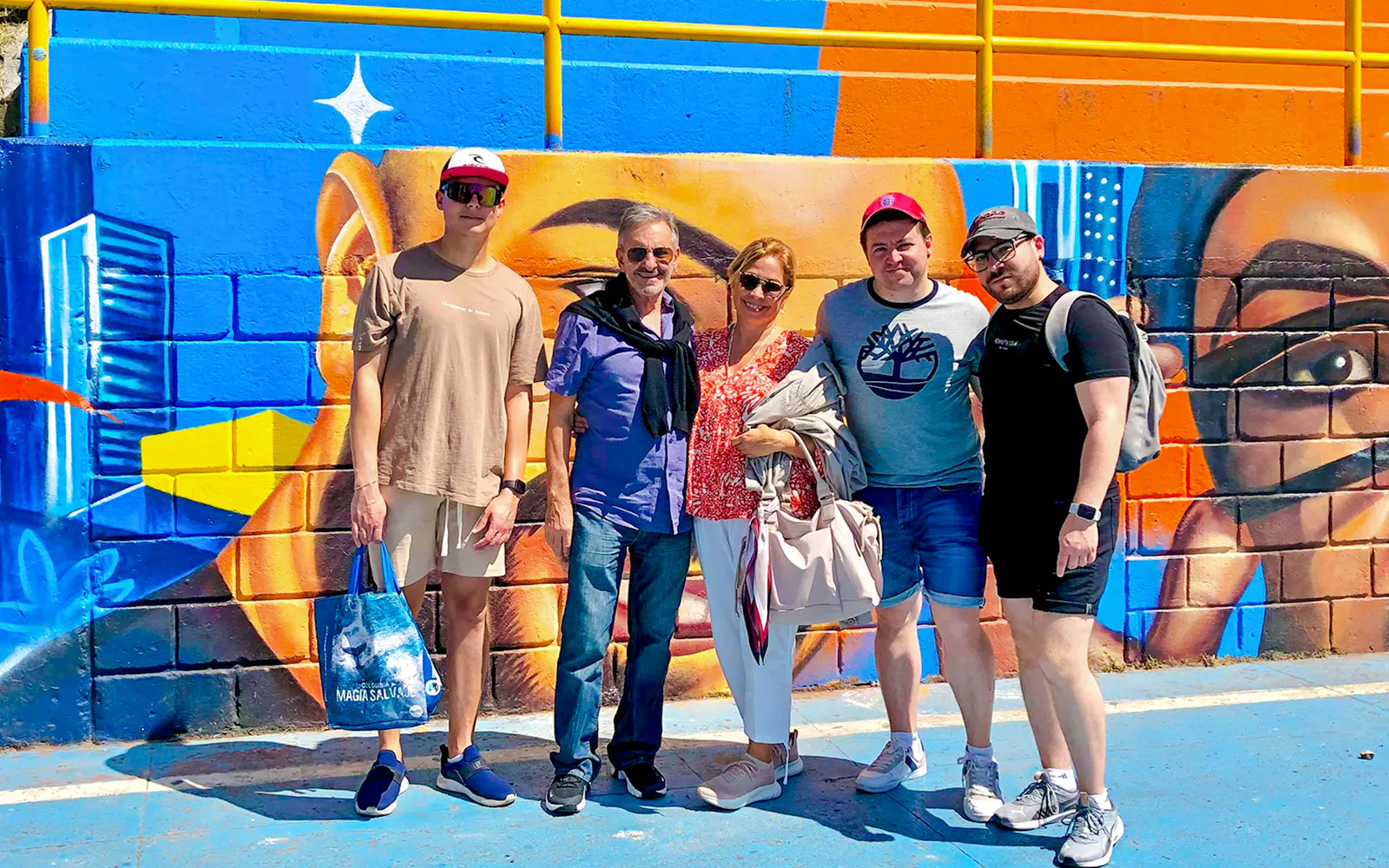 Guests standing in front of colorful graffiti at Medellin Comuna during the Graffiti, story & flavor tour.