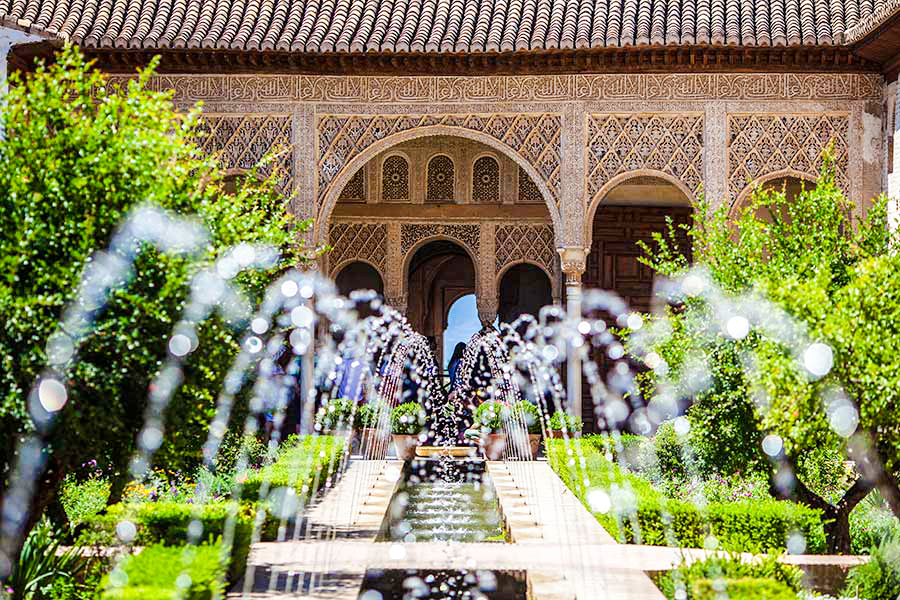 Courtyard with water channel and arches in Generalife Gardens, Alhambra, Granada.
