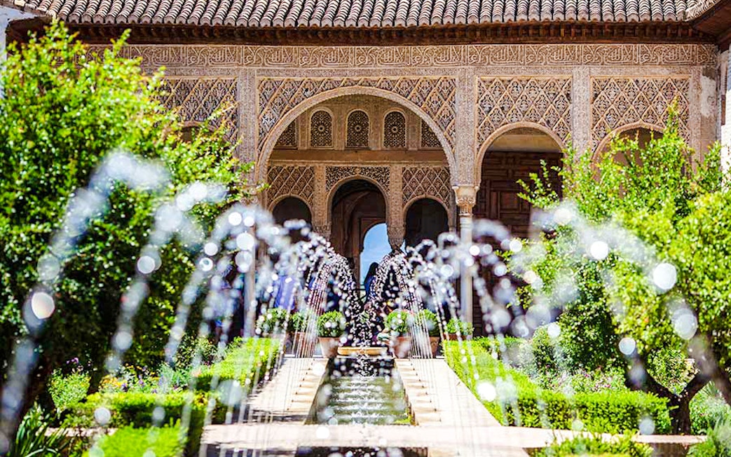 Courtyard with water channel and arches in Generalife Gardens, Alhambra, Granada.