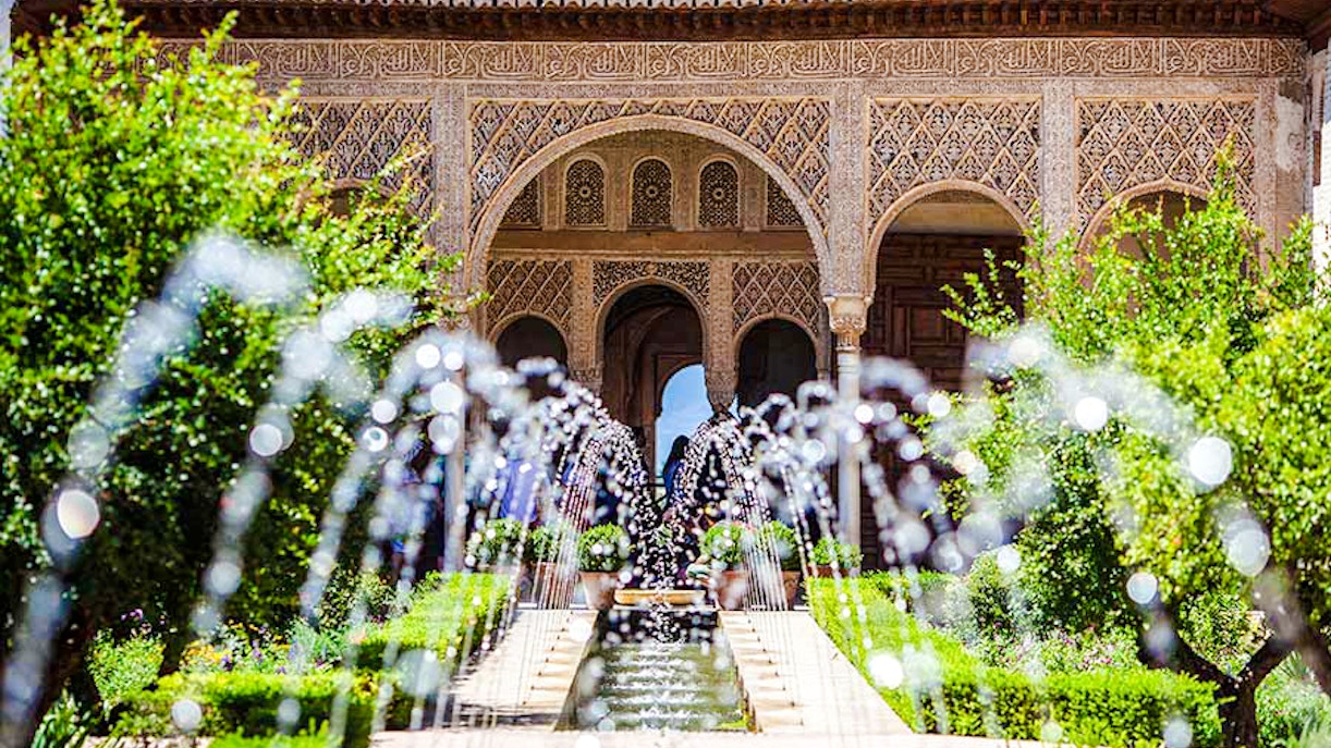 Courtyard with water channel and arches in Generalife Gardens, Alhambra, Granada.