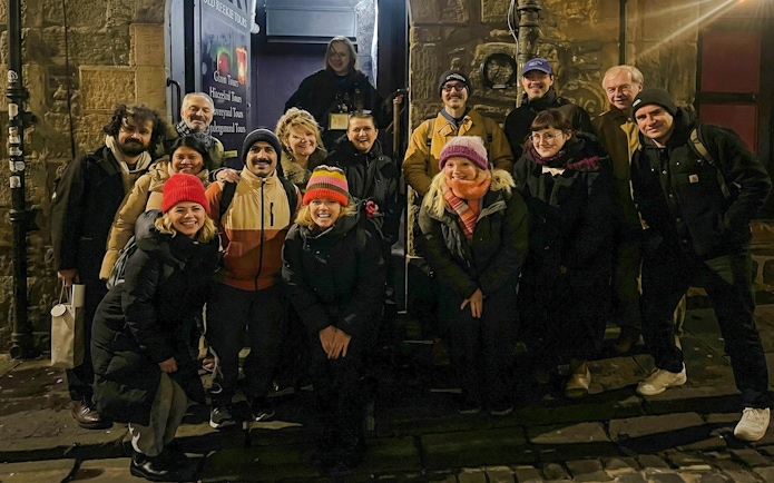 Tourists gathered outside a historic building during a night tour.