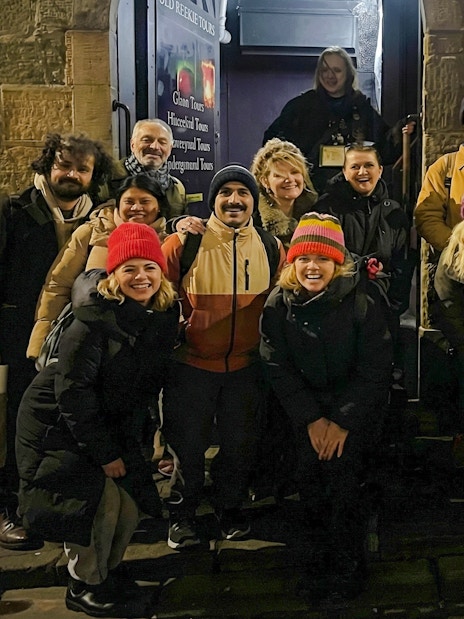 Tourists gathered outside a historic building during a night tour.