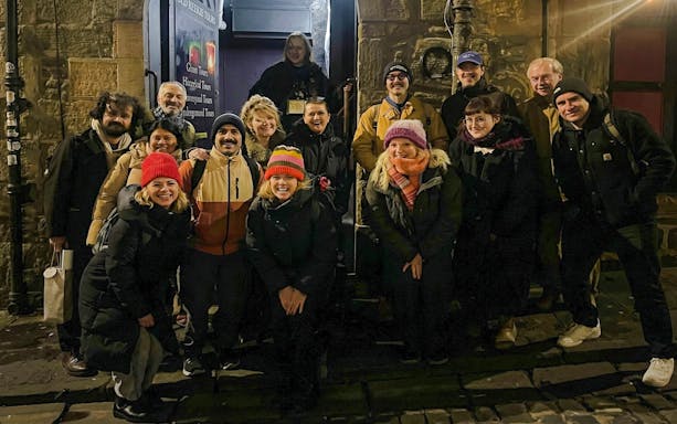 Tourists gathered outside a historic building during a night tour.
