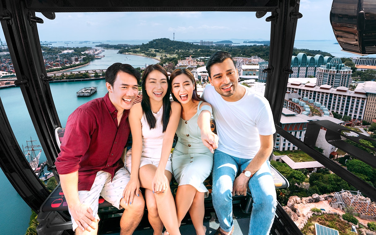 Group enjoying Singapore Cable Car ride with city and ocean view.