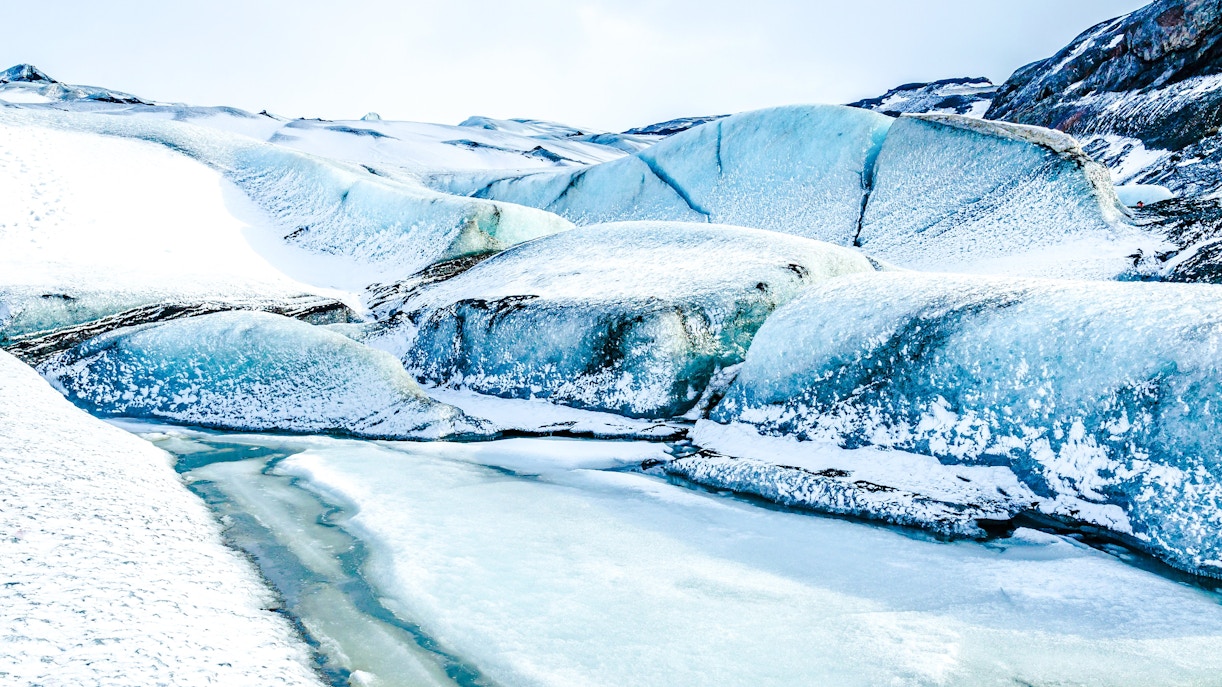 Myrdalsjokull Glacier's icy landscape with blue ice formations in Iceland.