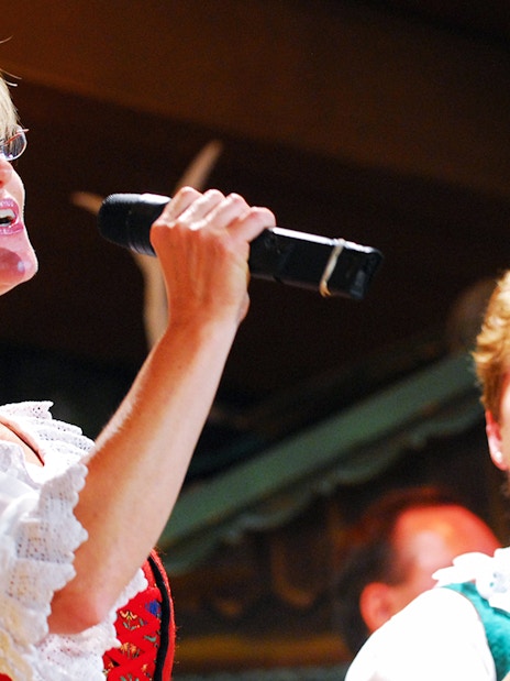 Singers performing at Tyrolean Evening Folk Show in traditional attire.