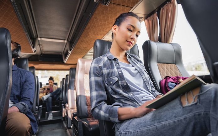 Passengers seated inside an AC transfer bus for the Golden Circle & Glacier Snowmobile Tour.