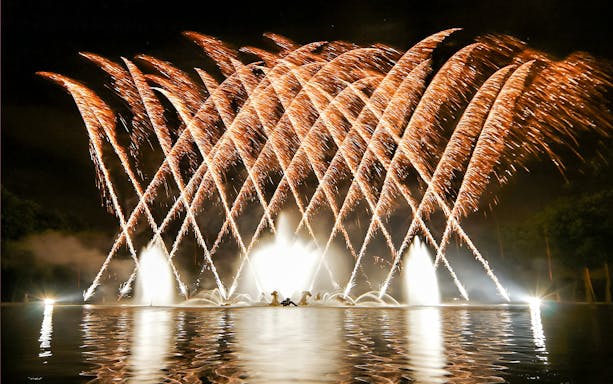 Versailles Night Fountains Show with fireworks illuminating the water.