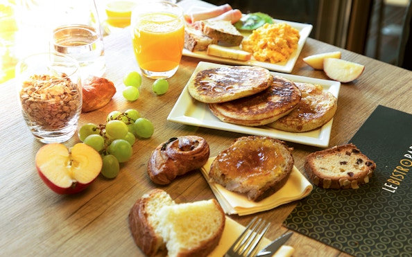 Assorted breakfast items at Le Bistro Parisien, Paris, with pancakes, fruit, and pastries.