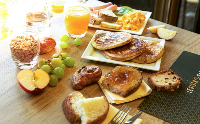 Assorted breakfast items at Le Bistro Parisien, Paris, with pancakes, fruit, and pastries.