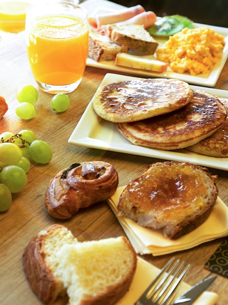 Assorted breakfast items at Le Bistro Parisien, Paris, with pancakes, fruit, and pastries.