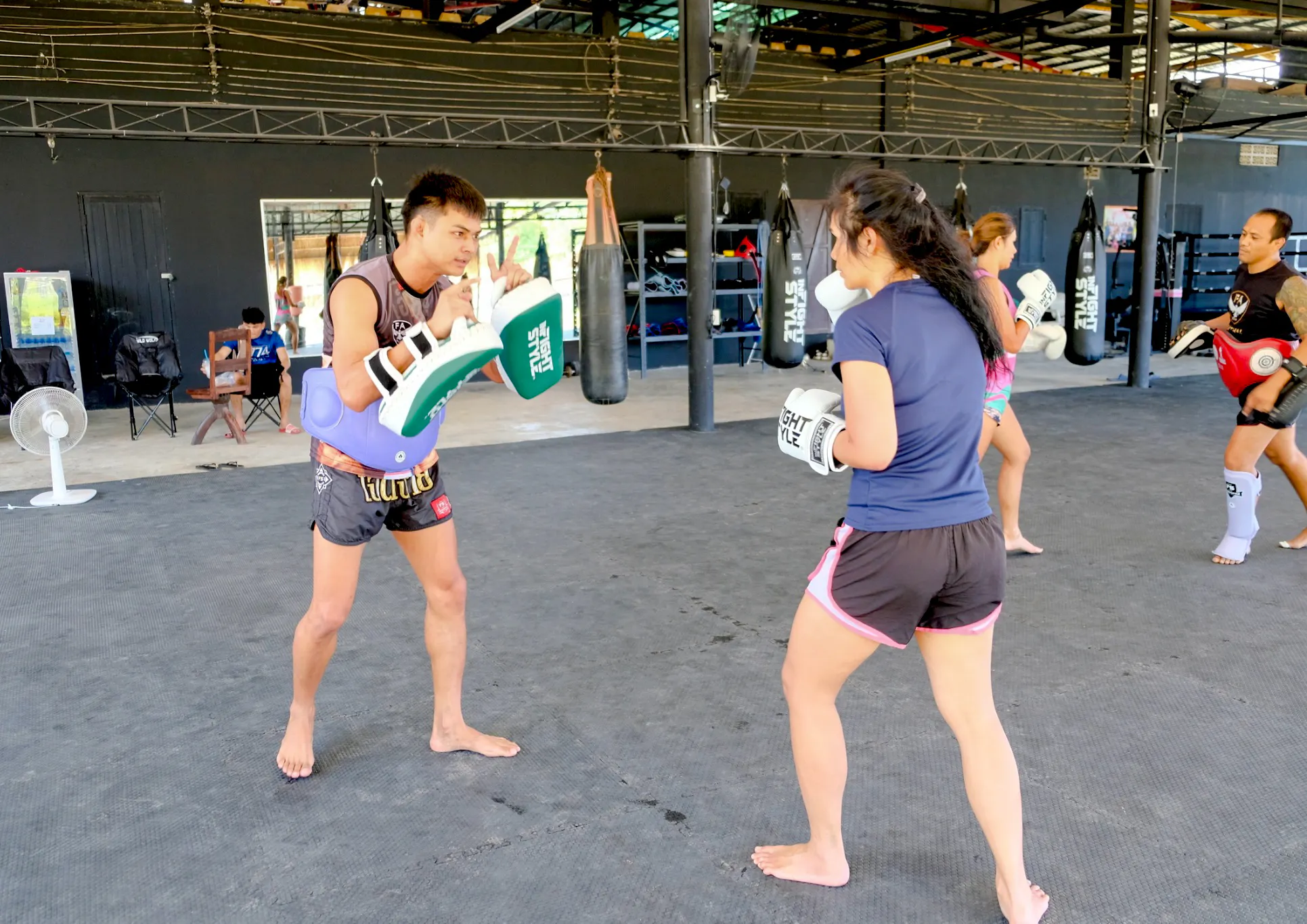 Beginners practicing Muay Thai boxing techniques in a Krabi gym class.