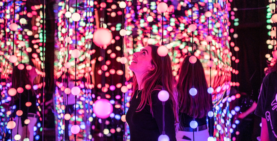 Visitor enjoying colorful light installation at Dopamine Land.