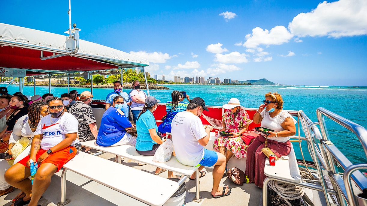 Passengers on a boat looking out at the ocean, off the coast of Waikiki
