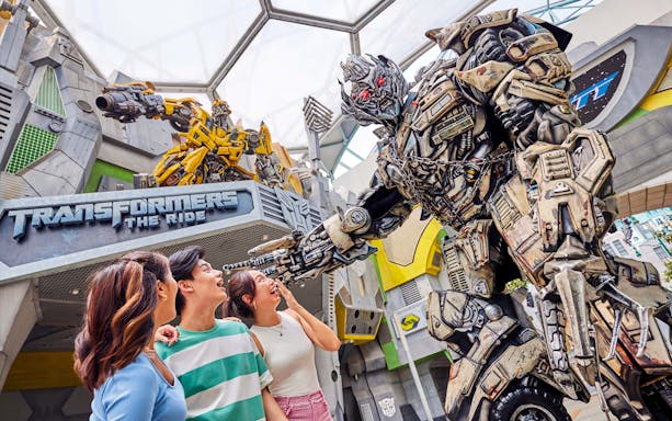 Visitors interacting with a Transformer character at Universal Studios Singapore.