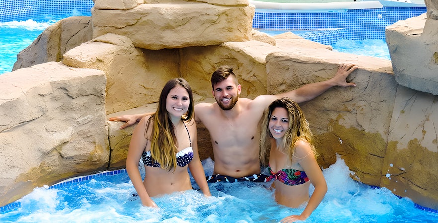 Friends relaxing in a Jacuzzi at Aquopolis Torrevieja water park.