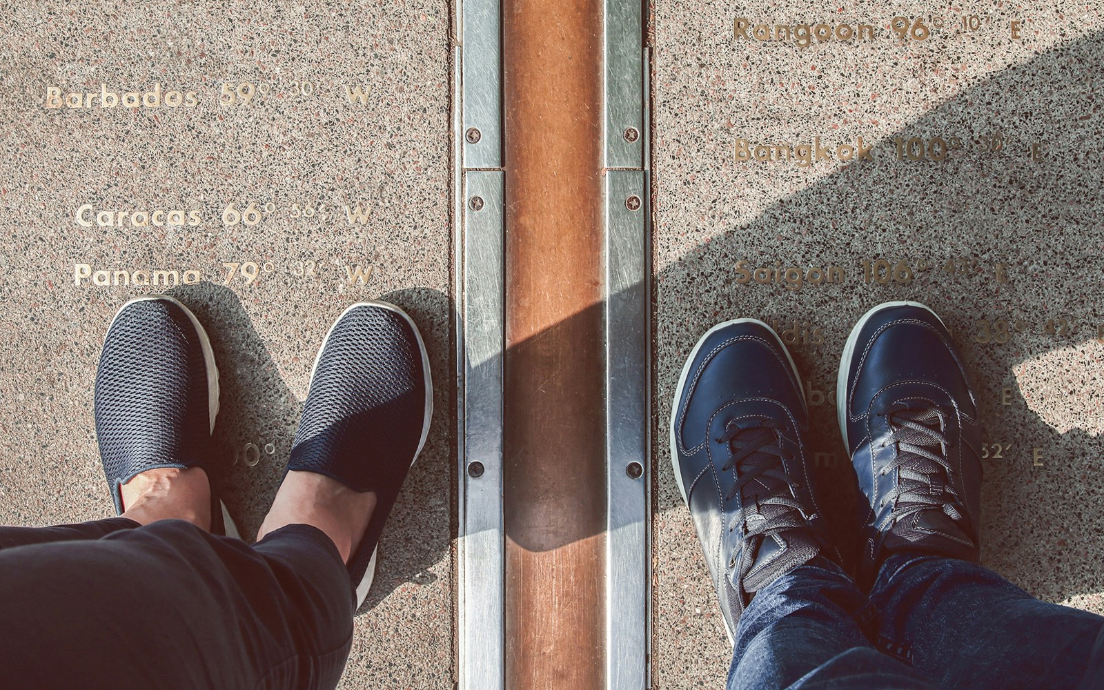 Legs straddling the Prime Meridian line at Greenwich, London.