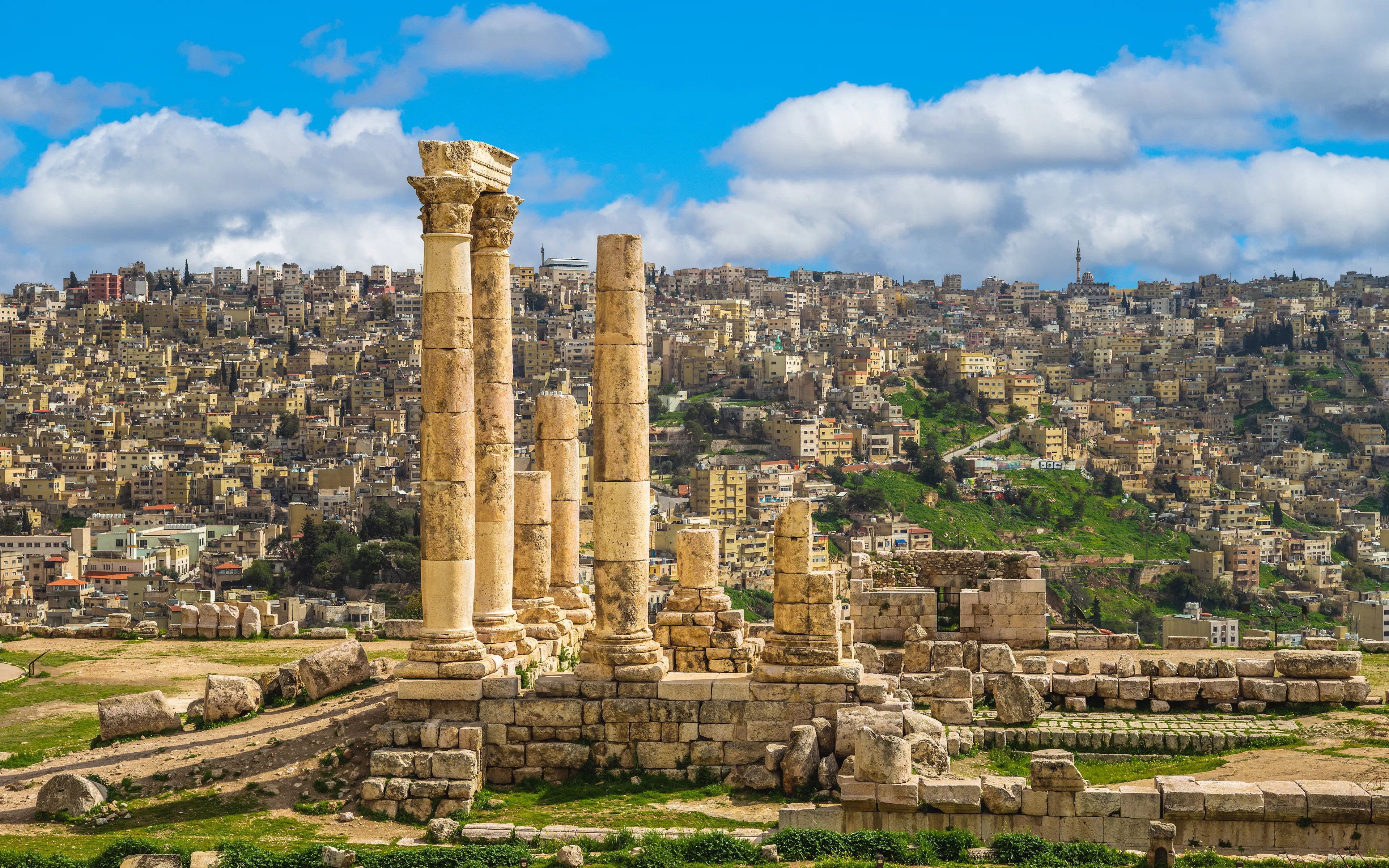 Temple of Hercules ruins at Amman Citadel with cityscape of Amman, Jordan in the background.