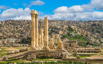 Temple of Hercules ruins at Amman Citadel with cityscape of Amman, Jordan in the background.