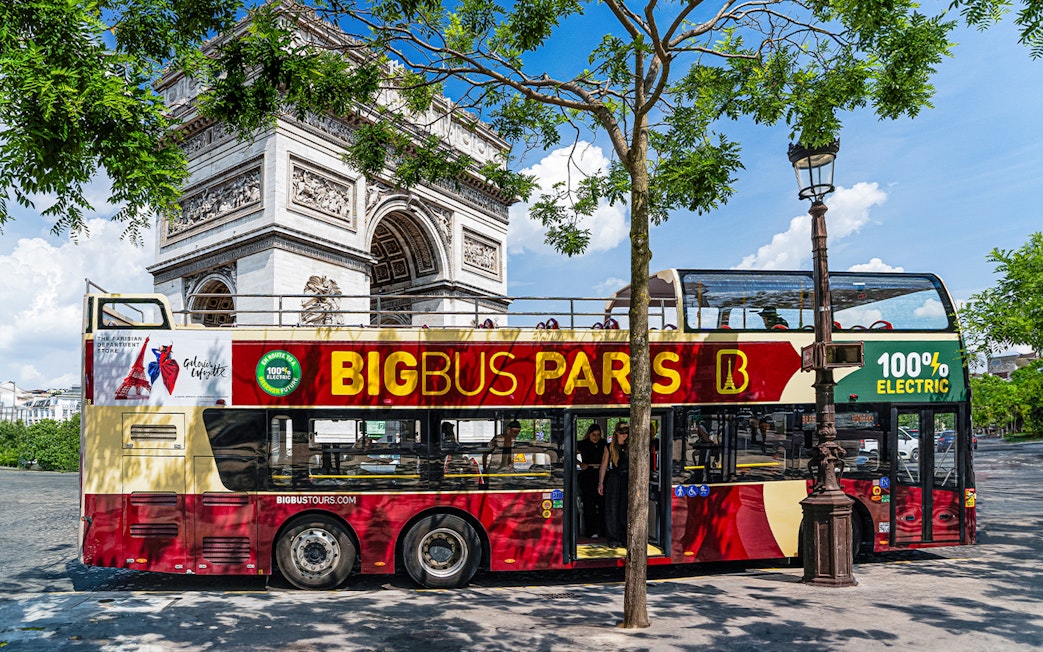 Big Bus Paris tour near Arc de Triomphe, featuring an electric double-decker bus.