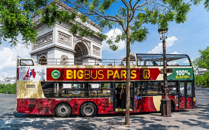 Big Bus Paris tour near Arc de Triomphe, featuring an electric double-decker bus.