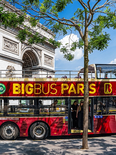 Big Bus Paris tour near Arc de Triomphe, featuring an electric double-decker bus.