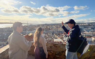 Tourist with guide overlooking Lisbon from São Jorge Castle viewing area.