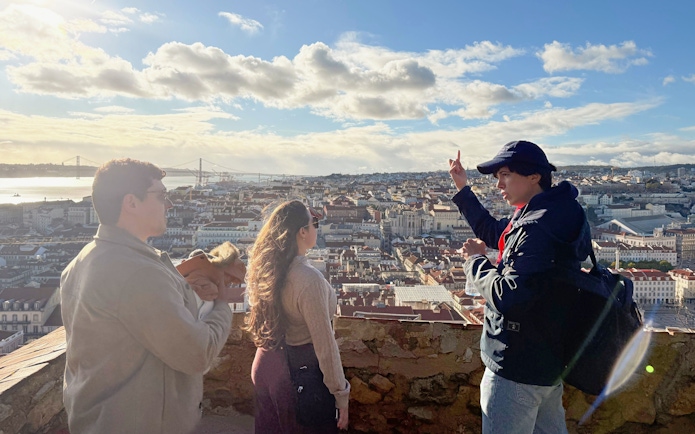 Tourist with guide overlooking Lisbon from São Jorge Castle viewing area.