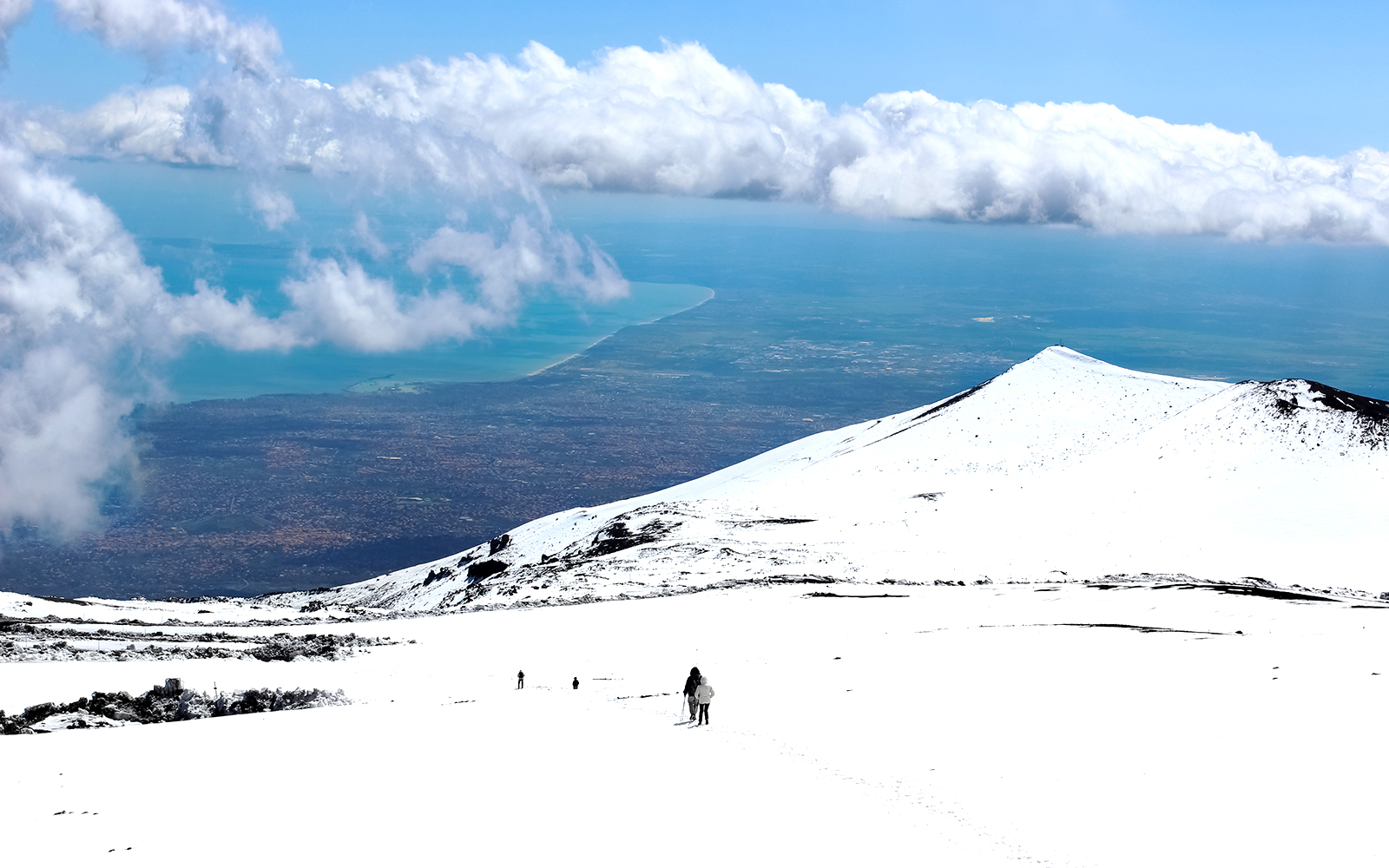 Mount Etna skiing with panoramic views of snow-covered slopes and volcanic landscape in Sicily, Italy.