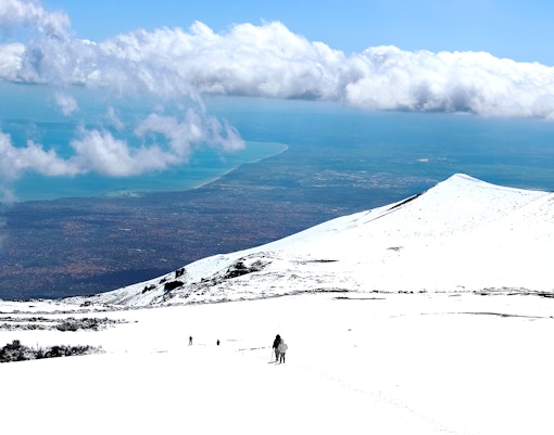 Mount Etna skiing with panoramic views of snow-covered slopes and volcanic landscape in Sicily, Italy.
