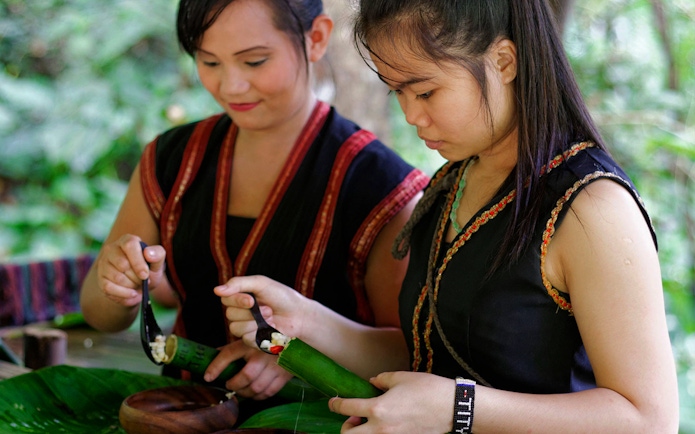 Women preparing traditional food at Mari Mari Cultural Village tour.