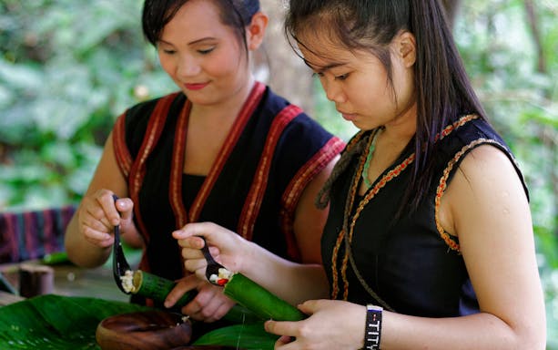 Women preparing traditional food at Mari Mari Cultural Village tour.