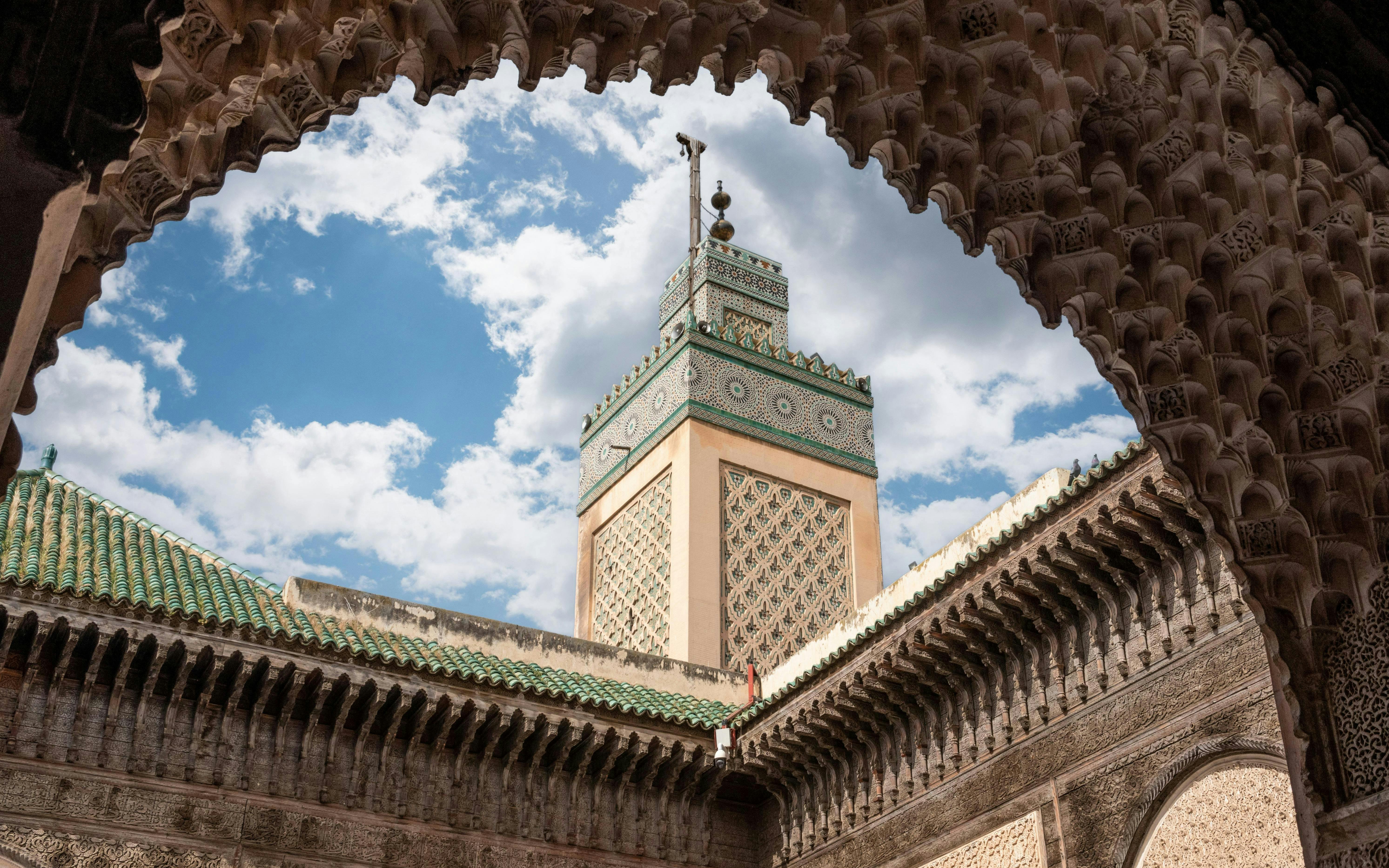 Traditional facade and minaret at Bou Inania Madrasa courtyard, Fes medina.