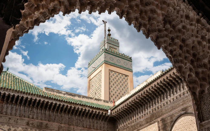 Traditional facade and minaret at Bou Inania Madrasa courtyard, Fes medina.