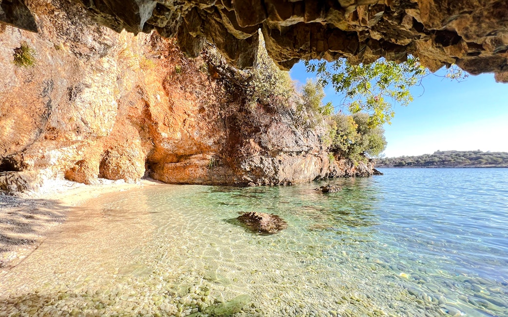 Clear waters and rocky cliffs at Bay of Grama, Blue Caves Albania tour.