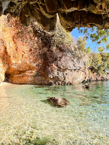 Clear waters and rocky cliffs at Bay of Grama, Blue Caves Albania tour.