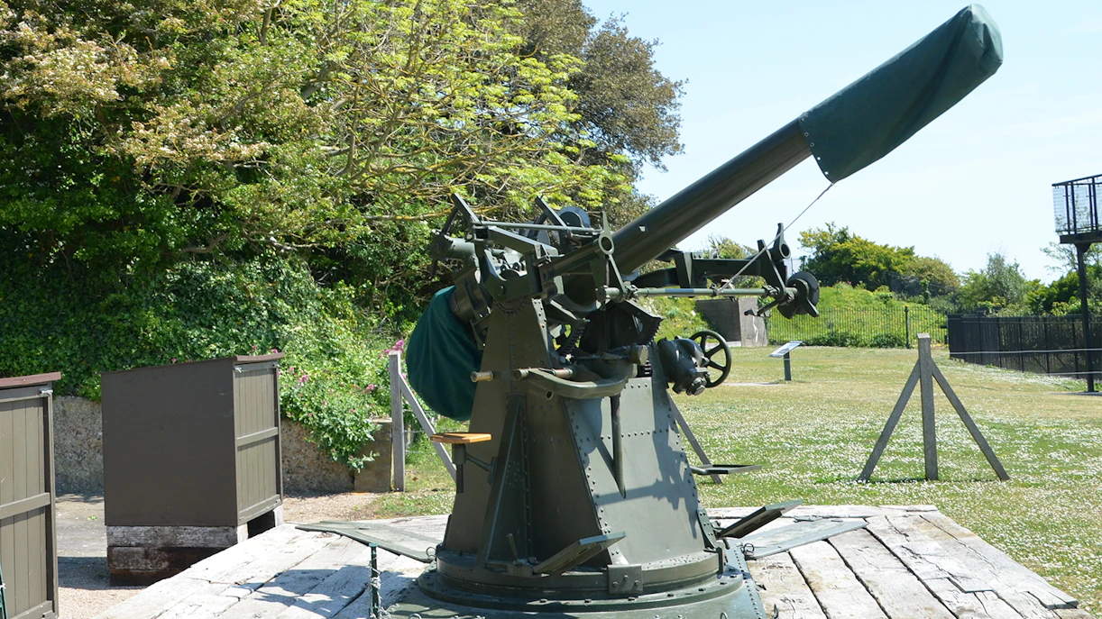 Anti-aircraft gun at Dover Castle's Secret Wartime Tunnels, surrounded by greenery.