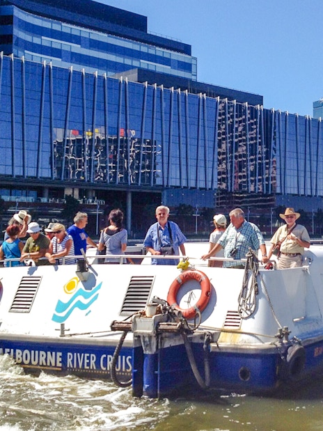 Melbourne River Cruises boat on Yarra River with city skyline in background.