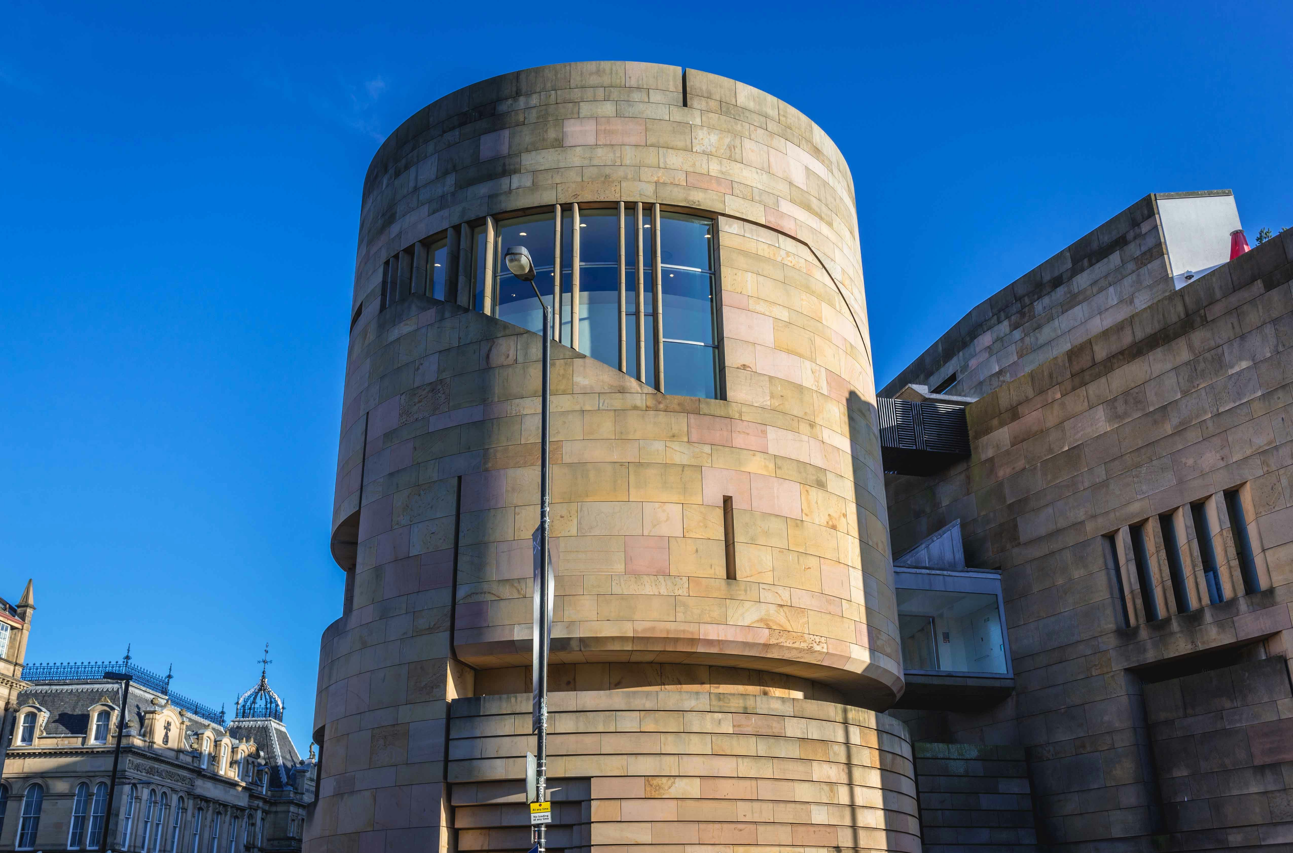 Visitors exploring the grand interior of the National Museum of Scotland, a popular day trip destination in Edinburgh