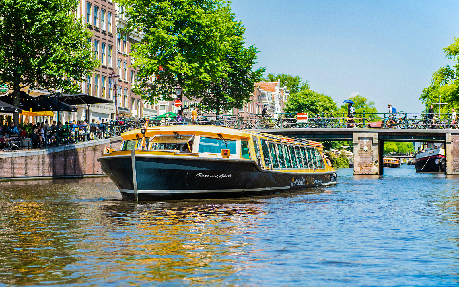 Sail Amsterdam boat cruising through canal during daytime.