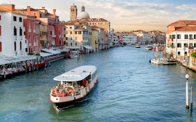 Vaporetto cruising on the Grand Canal in Venice with colorful buildings in the background.