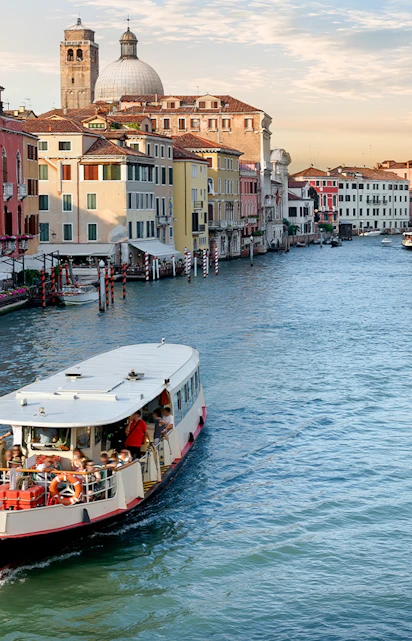 Vaporetto cruising on the Grand Canal in Venice with colorful buildings in the background.