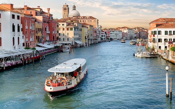Vaporetto cruising on the Grand Canal in Venice with colorful buildings in the background.